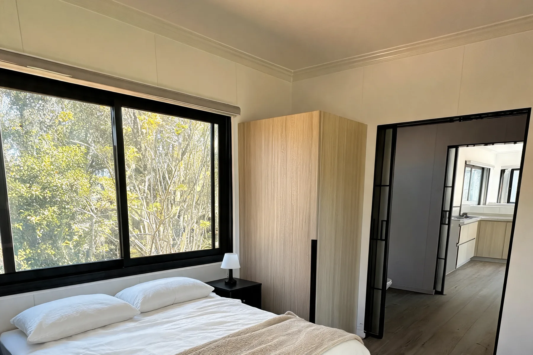 Finished bedroom with black frame aluminium window and built in wardrobe in a Lima modular home
